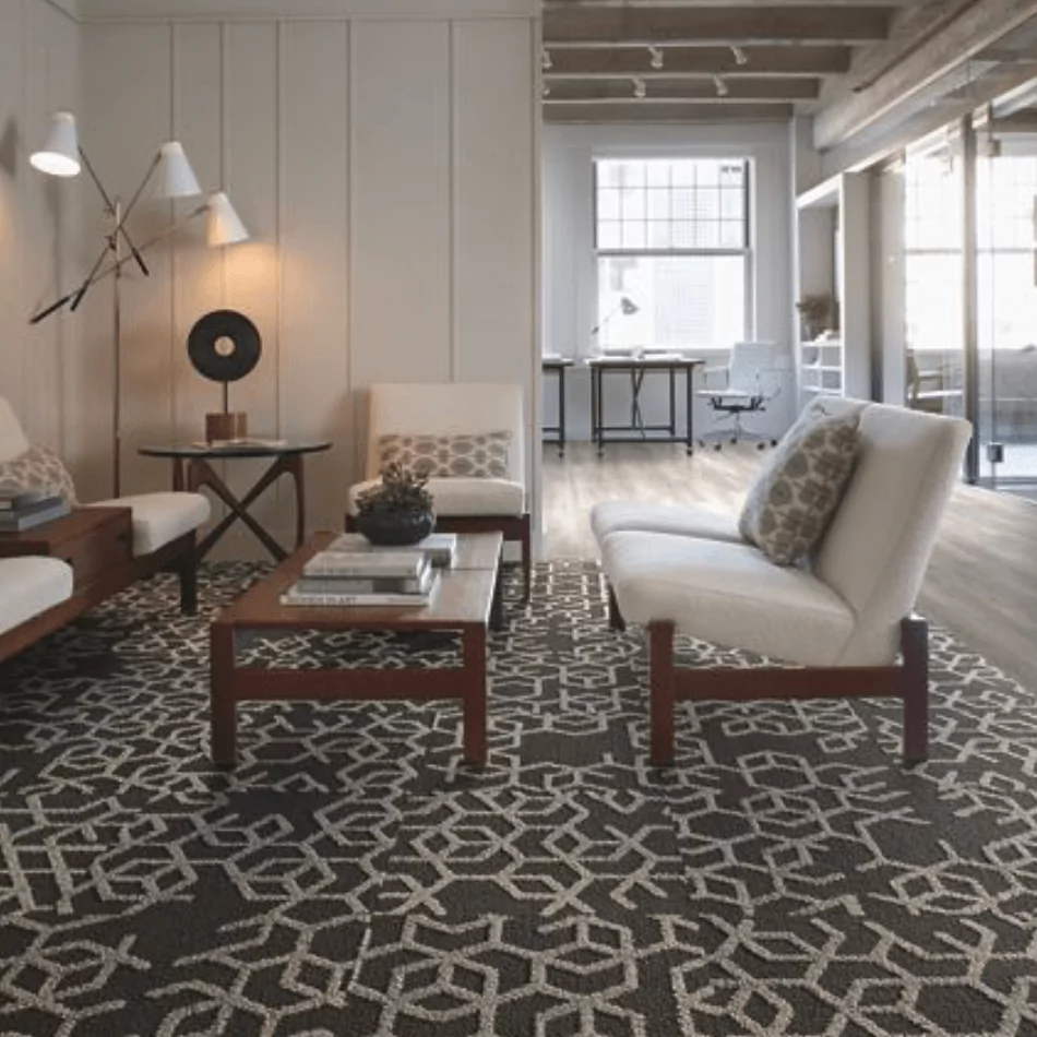 Modern living room featuring Carpet Tile 4 with geometric pattern, stylish furniture, and a bright workspace in the background.