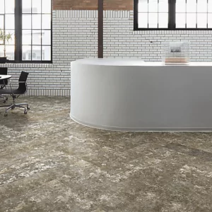 Carpet tile flooring in a modern interior space featuring a curved reception desk and large windows.