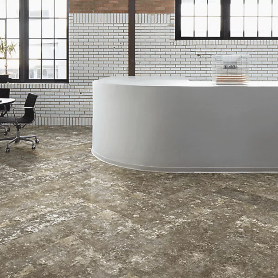 Luxury vinyl tile flooring in modern office setting with curved reception desk and black office chairs, showcasing the LVT 2 product by Furniture Soup.