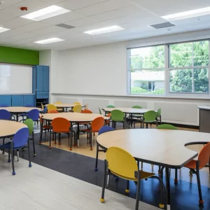 Classroom setting featuring colorful chairs and tables, designed for educational use, emphasizing a vibrant and engaging learning environment.