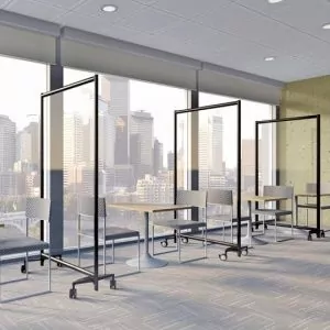 Office dividers and screens in a modern workspace, featuring transparent panels and rolling bases, designed for flexibility and privacy in office environments.