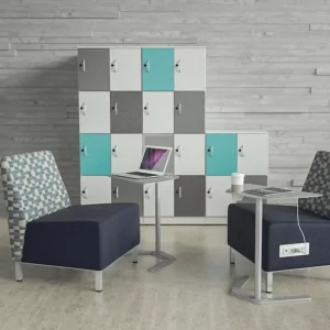 Lockers 7 in a modern office setting, featuring a colorful locker unit with teal, gray, and white doors, accompanied by two stylish chairs and a small table with a laptop and coffee cup.