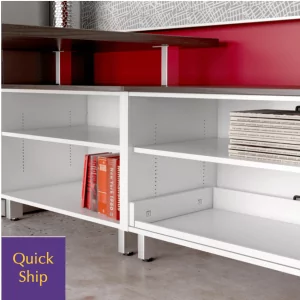 Low bookcase credenza with open shelving, featuring books and magazines, against a modern backdrop, labeled "Quick Ship" for fast delivery options.
