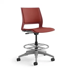 Red ergonomic stool with adjustable height and footrest, designed for office use, featured in a workspace setting by Furniture Soup.