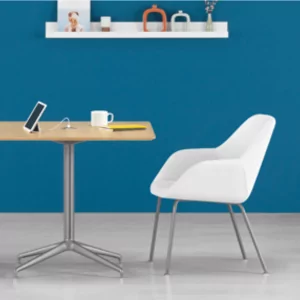 OTG 10901B Meeting and Guest Chair in modern office setting with wooden table, tablet, and coffee cup against blue wall.