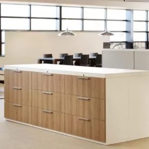 Modern office storage cabinet with wooden drawers and a white countertop, designed for organizational efficiency in workspace environments.