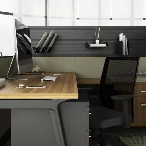 Modern office workspace featuring a wooden desk, ergonomic chair, computer monitor, and organized paper management accessories.