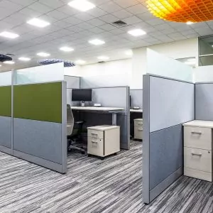 Modern office cubicles featuring gray partitions, ergonomic chairs, and storage units, showcasing the New Cubicle Global Evolve 10 in a well-lit workspace.