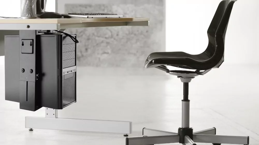CPU holder mounted under a desk with a sleek black design, accompanied by a modern office chair and keyboard setup, showcasing ergonomic office furniture solutions.