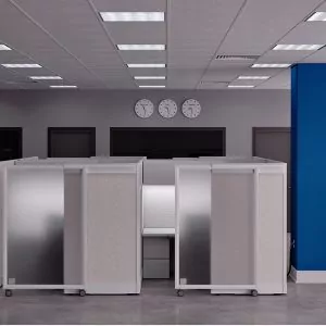Sliding door cubicles in modern office setting with three clocks on the wall, showcasing the 'Slide Door 4' product by Furniture Soup.